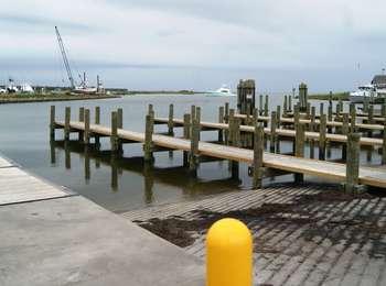 Non-slip ramps leading down into the marina waters with finger piers between.