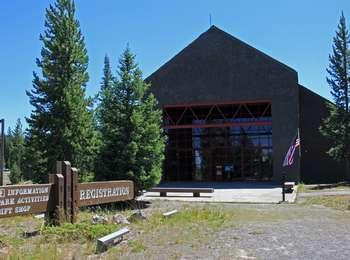 A modern stone building with large glass windows and doors, with metal acccents