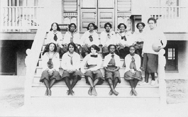 Student basketball players sit on steps on group photo 