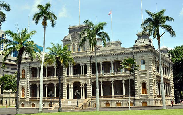 Exterior of 'Iolani Palace, Honolulu with lawn and pine trees in front