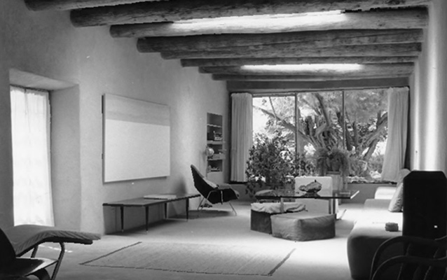 Interior view of Georgia O'Keeffe's home with a large window looking out. Beam ceiling.