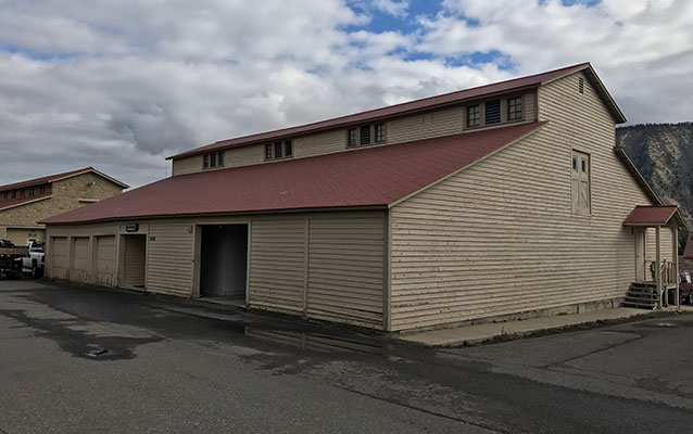 Tan wooden building with red tin roof.