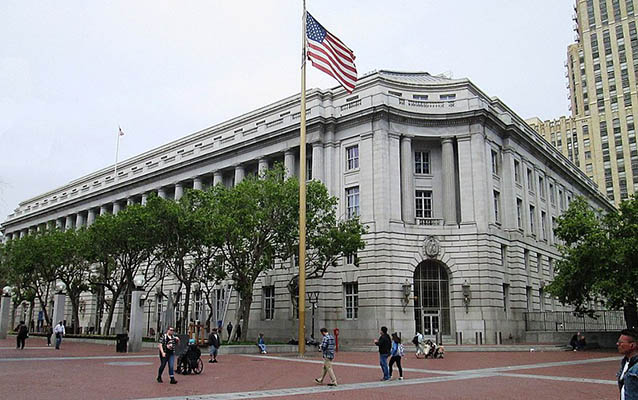 Exterior of the Federal Building with an American Flag flying in front.