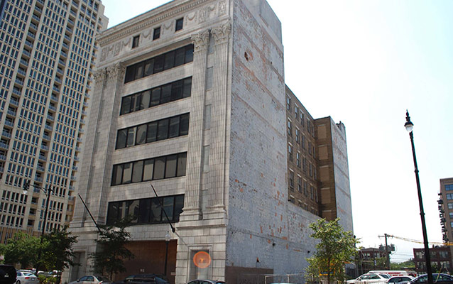 Seven story steel and concrete building with a flat roof. 