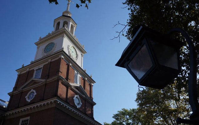independence hall and a lamppost in front of a blue sky