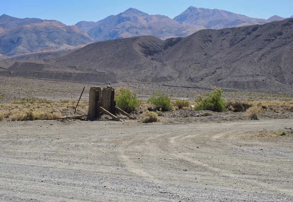 Old building and car with desert mountains in background