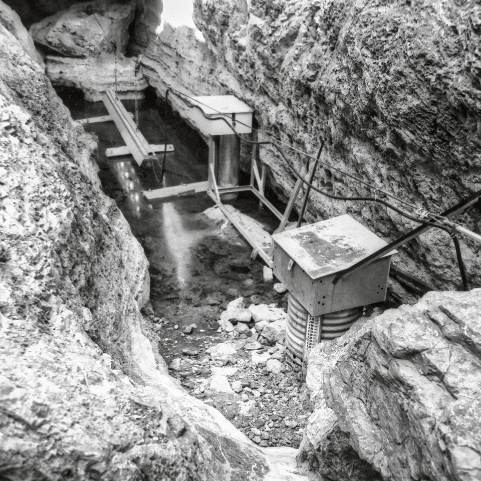 Monitoring equipment near water with rocky walls surrounding.