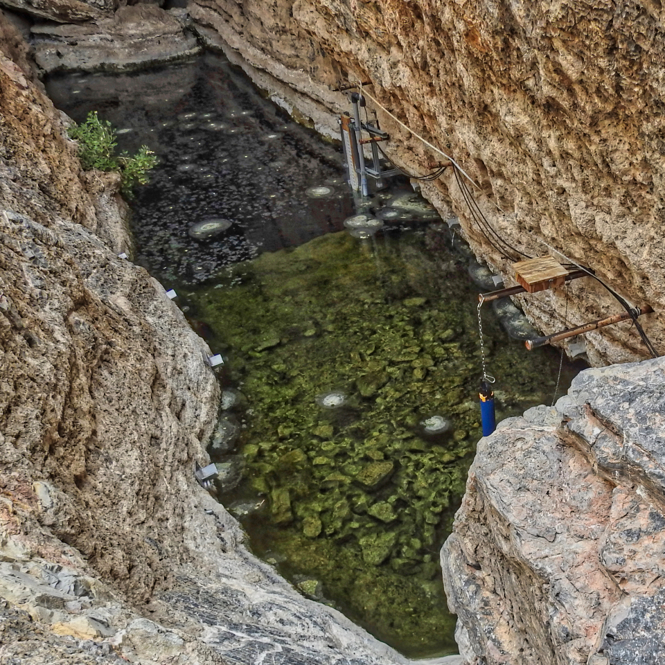 Monitoring equipment near water with rocky walls surrounding.
