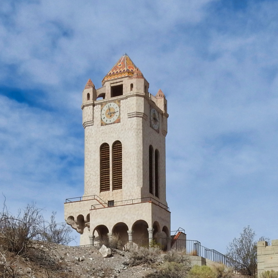 A clock tower with snow surrounding it.