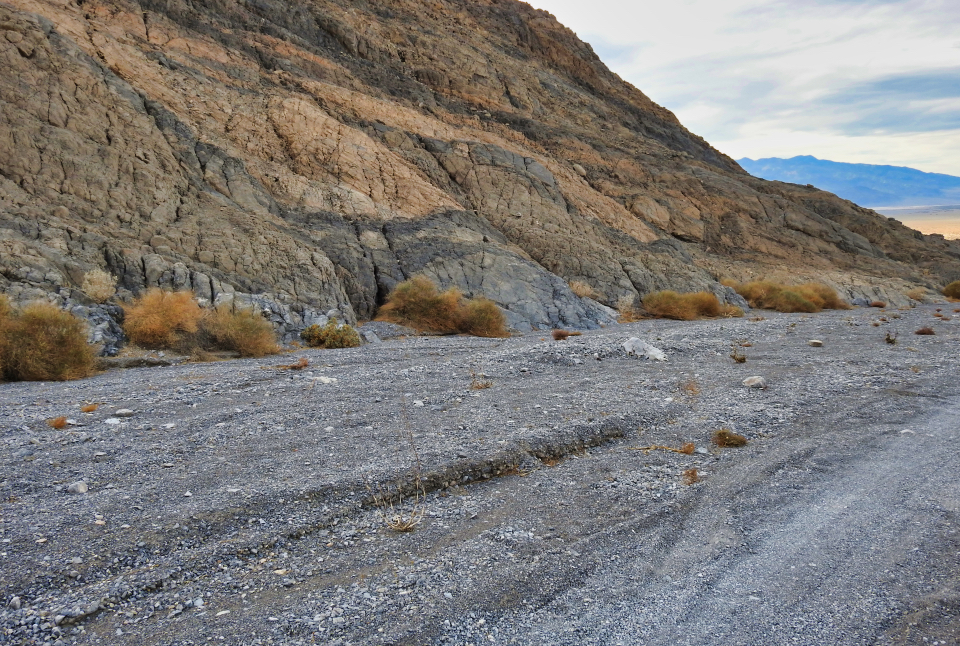 A car is stuck in floodwaters with man on dry land.