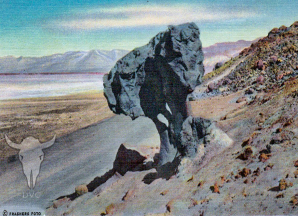 A large rock outcropping shaped like a mushroom next to a road.