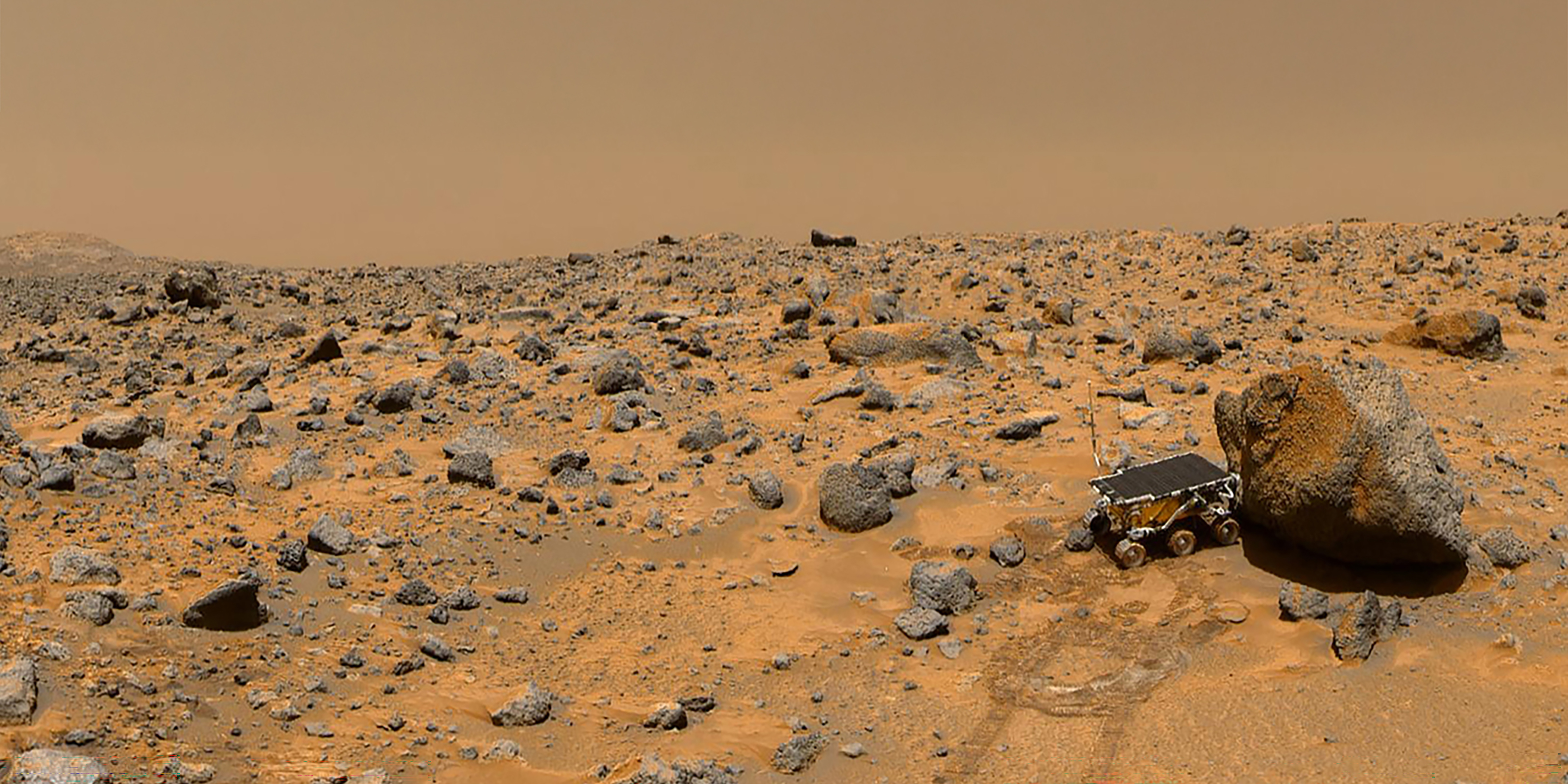 barren, rocky expanse, with a scattering of black boulders and smaller rocks covering the ground.