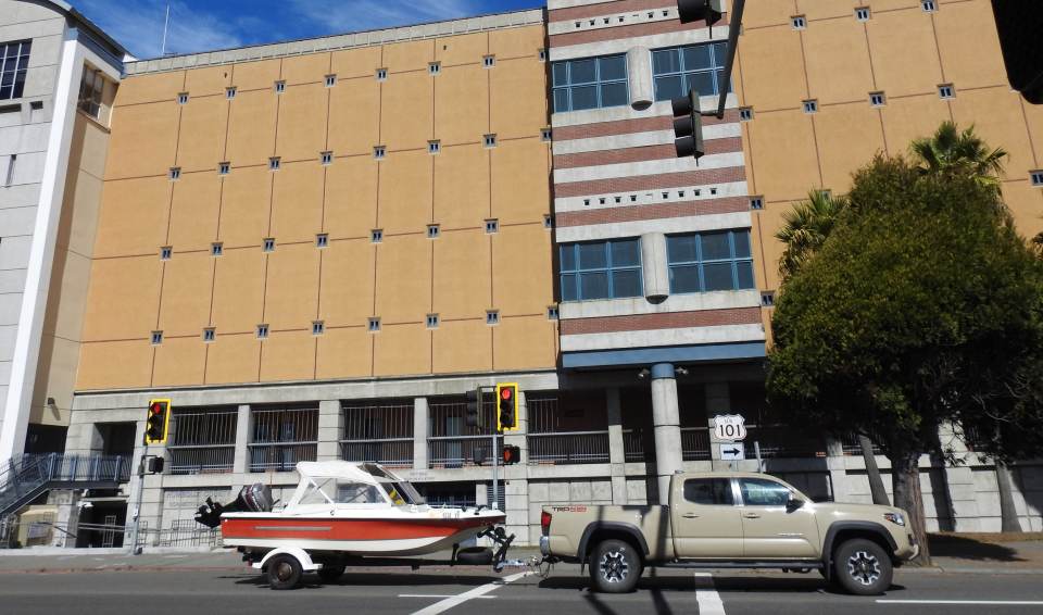 Old cars with men in front of building