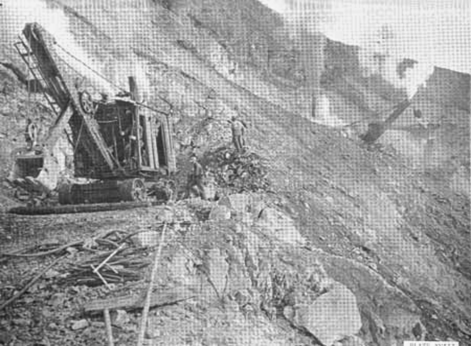 Tractor digging roadway on steep hillside