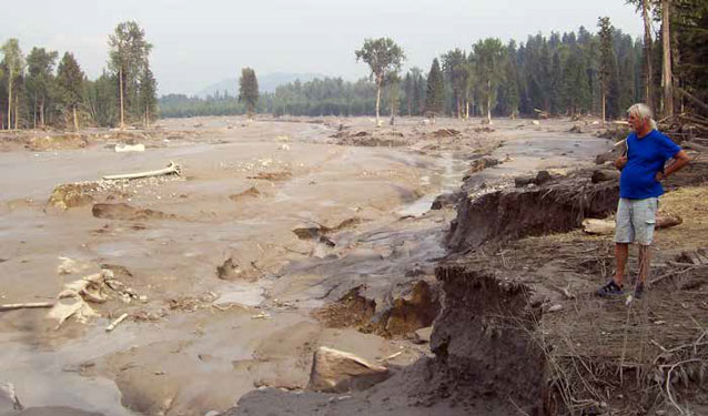 man standing near a devastated landscape of mud