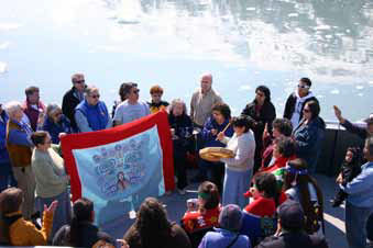 numerous people in a boat gathered around a blanket