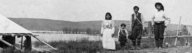 Family of four stands near lake