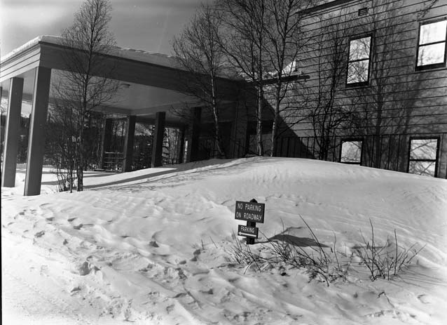 black and white image of a hotel covered in snow
