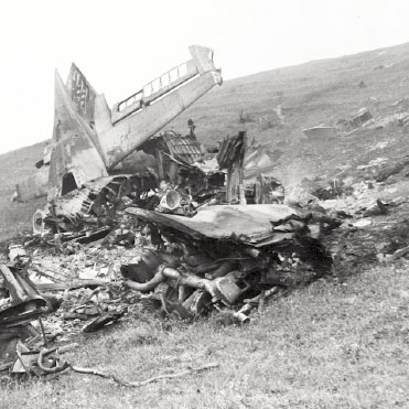 Black and white photo of airplane debris on hill