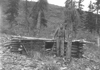 Adolph sits on the remnants of a trapper's cabin