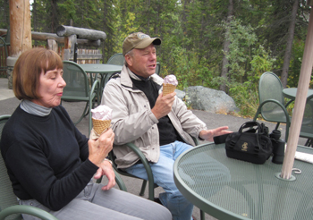 Two adults enjoy an ice cream cone.
