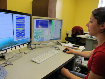 AEIC employee monitoring earthquakes in front of a computer.