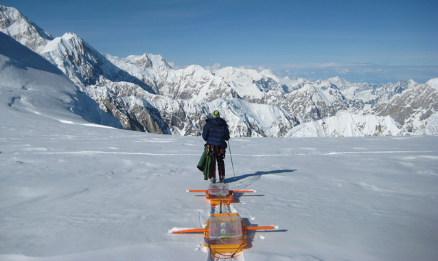 Scientist pulls ice penetrating equipment across the snow.