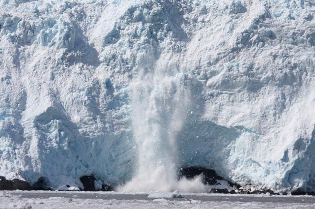 chunk of ice falling from a glacier into the ocean