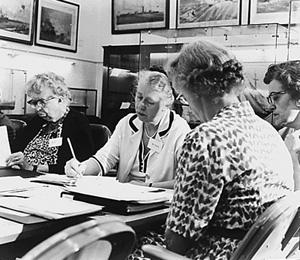 women working on documents around  table