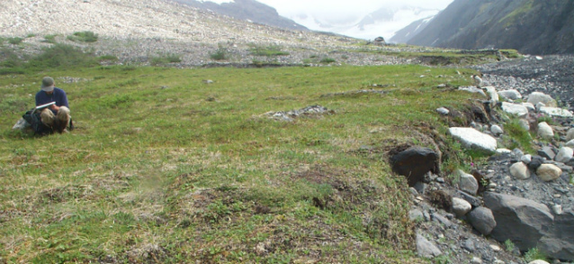 man writing in a notebook in open tundra