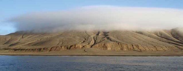 a rocky island covered by a cloud