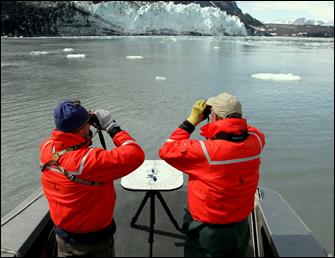 researchers scan the water with binoculars