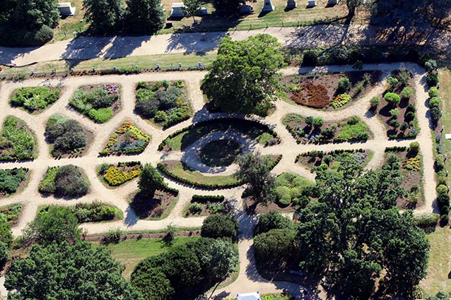 Aerial view of a formal garden, with symmetrical paths dividing garden beds.