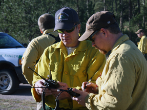 two firefighters track and maintain radios on an fire incident.