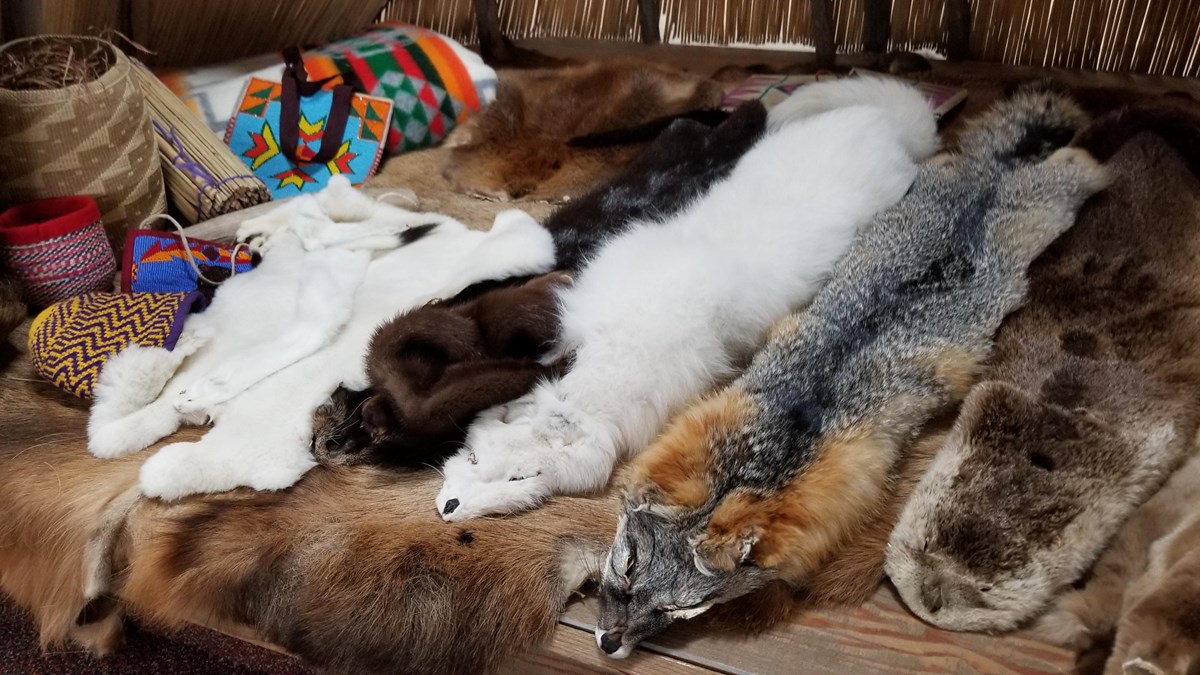 An array of animal furs, beaded bags, and woven baskets 