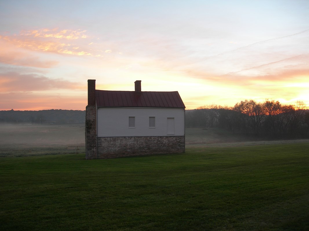 Sun rise and fog behind the historic Secondary House on the Best Farm. 