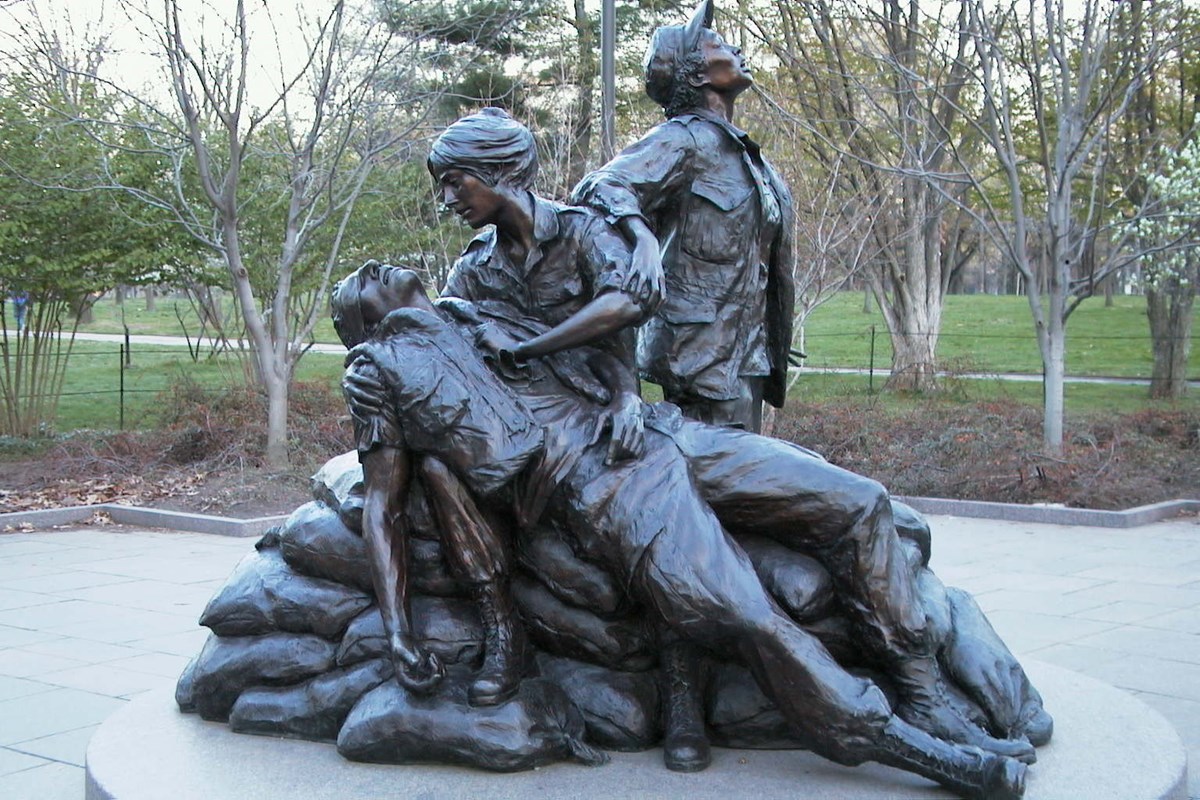 Bronze statue of three women with a wounded soldier.