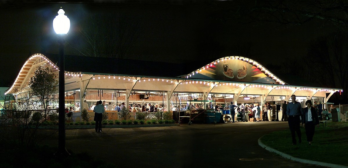 outdoor scene of open dance pavilion illuminated and evening dance crowd inside. 