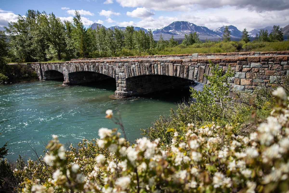 historic stone bridge with mountains behind
