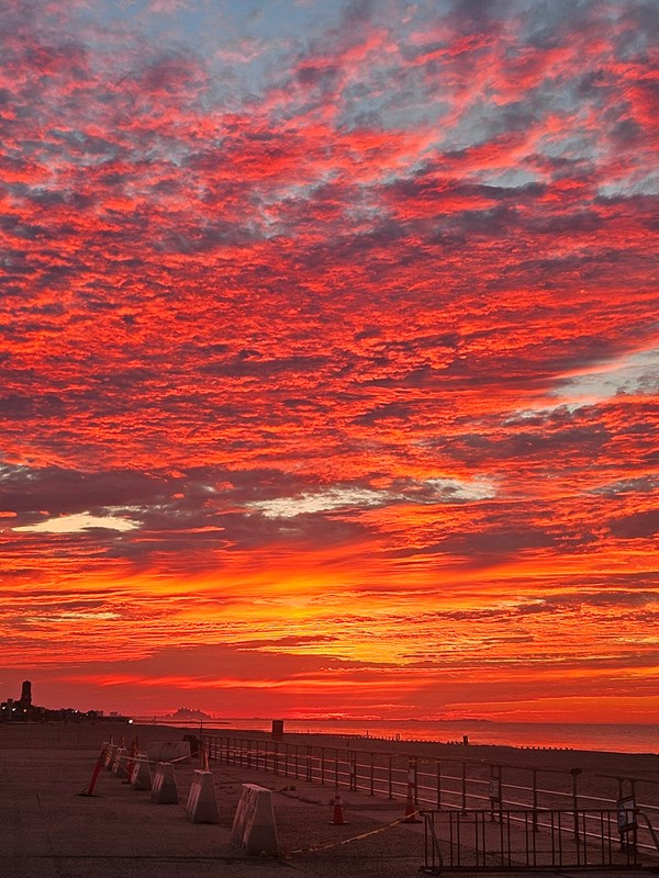 Red pink and orange sky over a body of water