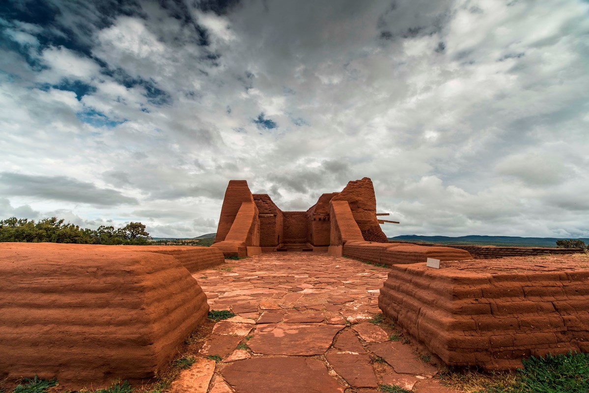 An adobe building under cloudy skies.