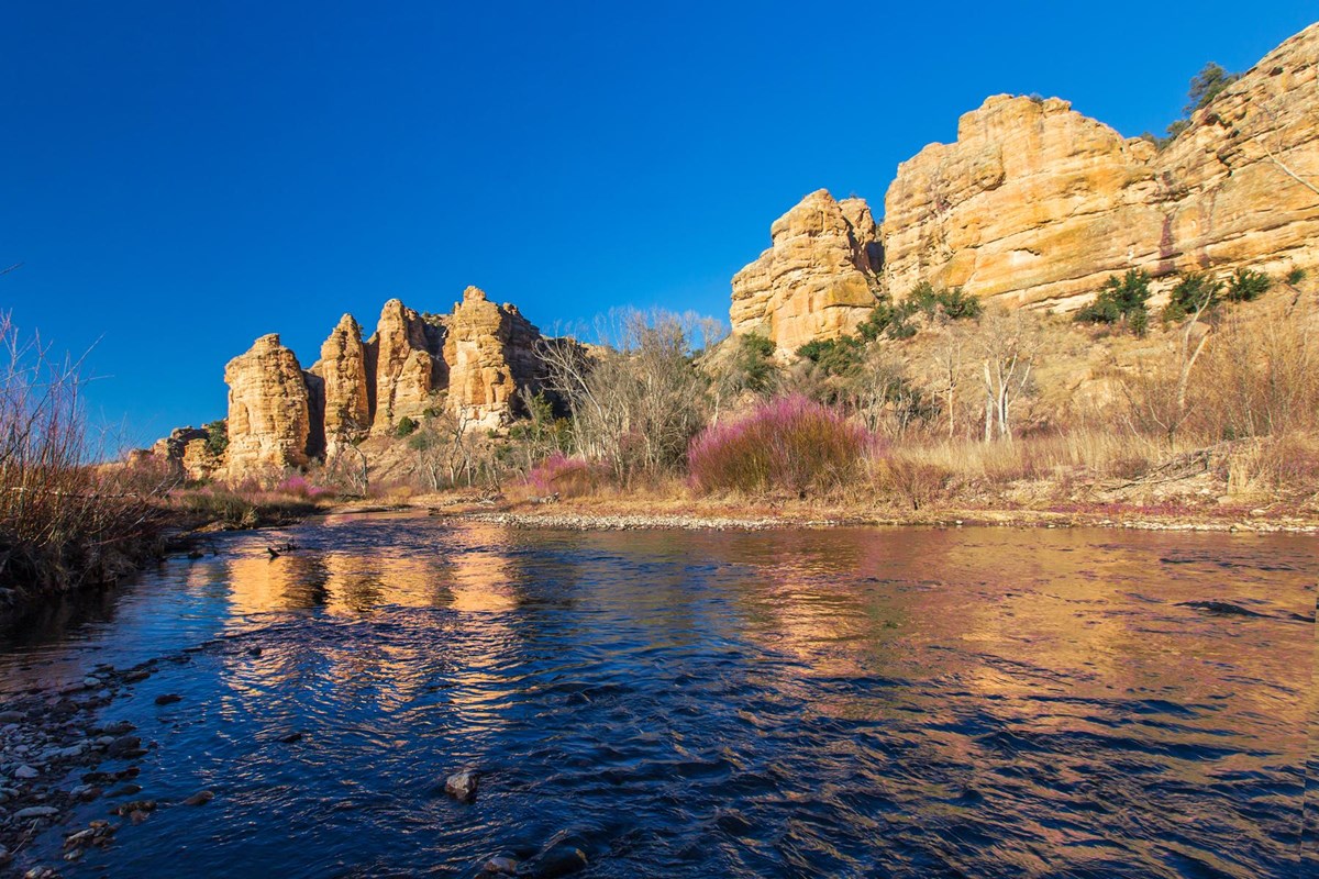 Eroded cliffs reflecting off a river 