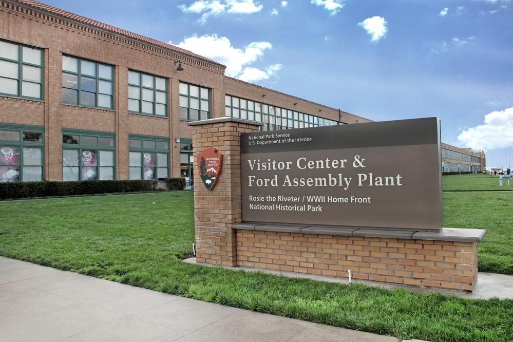 Entrance sign against the historic Ford buidling. 