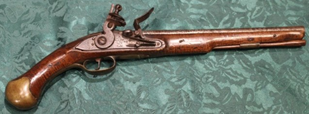 18th-century pistol on a green sheet