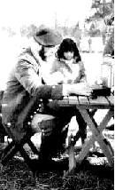 Reenactor showing child how to write with a quill pen