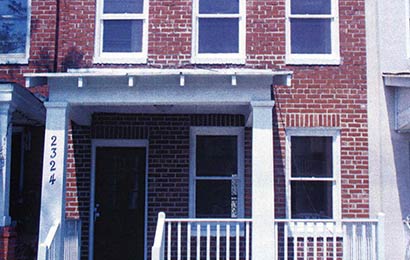 Front elevation of a two-story brick rowhouse.