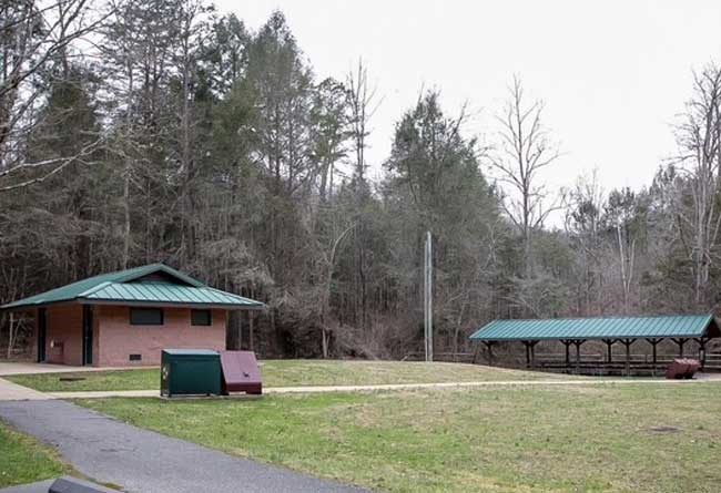Side angle of Sugar Run picnic shelter showing restrooms, grills, recycle bins and trash receptacles.