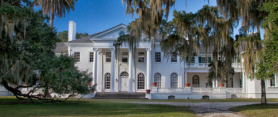 white, Georgian Revival style mansion under blue skies