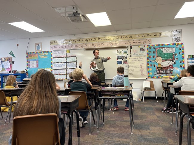 Park ranger presents in front of children in a classroom