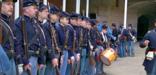 Line of Civil War re-enactors in uniforms with guns at Fort Point